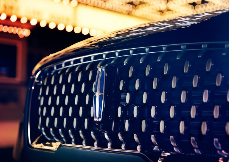 The Corsair Grand Touring grille shows floating chrome ovals that catch the glowing light of a theater marquee and frame the distinctive Lincoln Star | Pierre Lincoln in Lynnwood WA