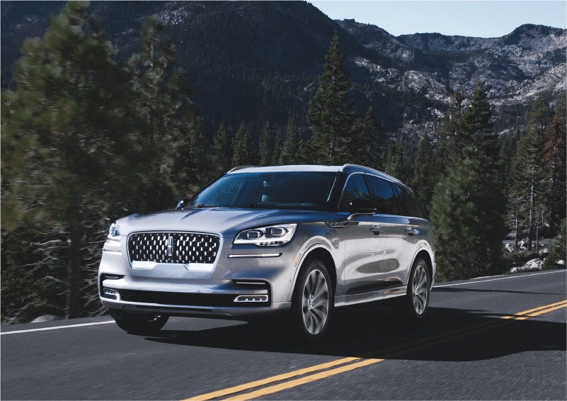 A 2023 Lincoln Aviator® Grand Touring SUV being driven on a winding road to demonstrate the capabilities of all-wheel drive | Pierre Lincoln in Lynnwood WA